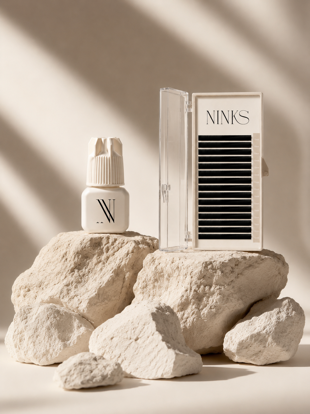 Ninks lash glue and lash tray on stone